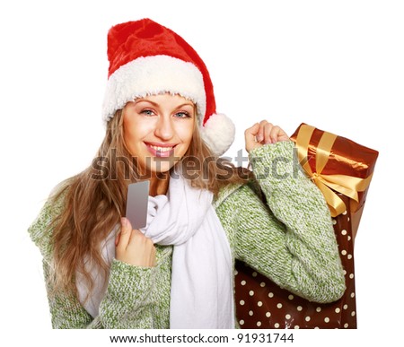 Friendly girl in santa hat with xmas gift showing blank business card isolated on white background
