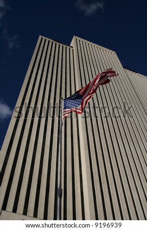 Looking up at white skyscraper with American Flag