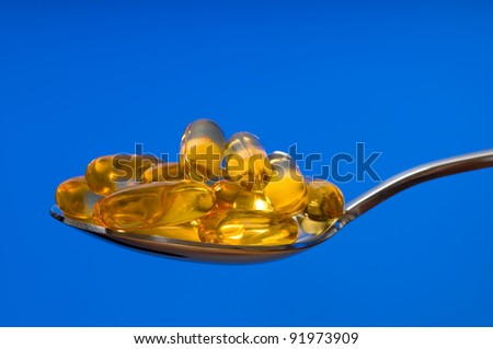 Omega 3 fish oil capsules on a spoon.