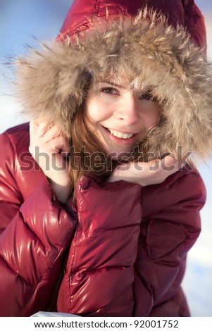 indoors winter portrait of young beauty in jacket with fur hood