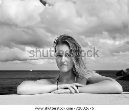 outdoor portrait of beautiful young blonde woman outdoors. azure sea and cloudy sky on background