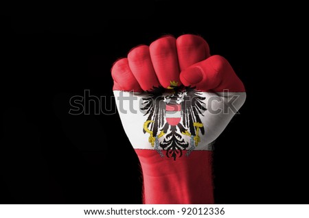 Low key picture of a fist painted in colors of austria flag