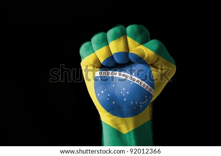 Low key picture of a fist painted in colors of brazil flag