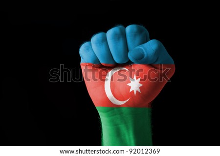 Low key picture of a fist painted in colors of azerbaijan flag