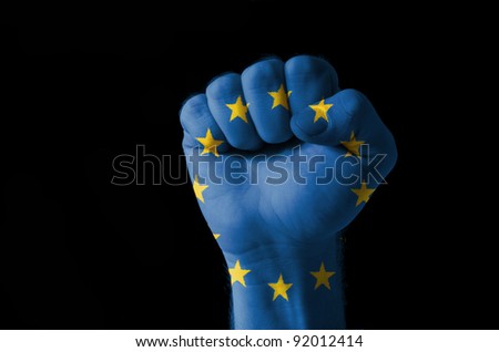 Low key picture of a fist painted in colors of europe flag