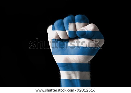 Low key picture of a fist painted in colors of greece flag