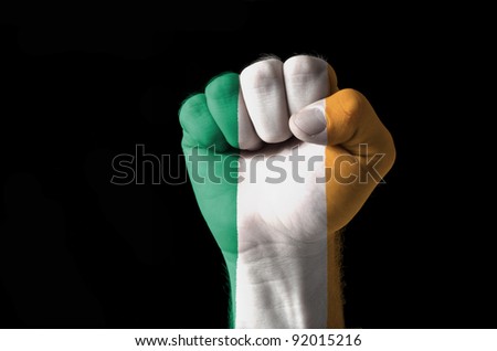 Low key picture of a fist painted in colors of ireland flag