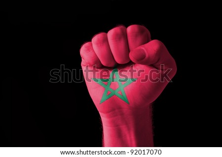 Low key picture of a fist painted in colors of morocco flag