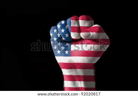 Low key picture of a fist painted in colors of american flag