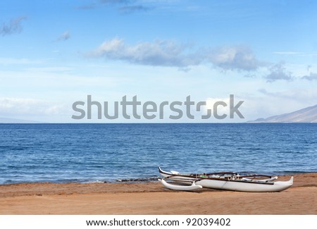 Maui outrigger adventure canoe on sandy ocean beach