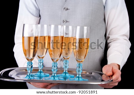 Male waiter serving champagne, black background