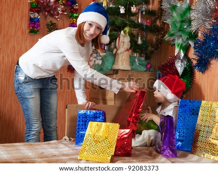 Happy mother and little son with Christmas gifts at  home