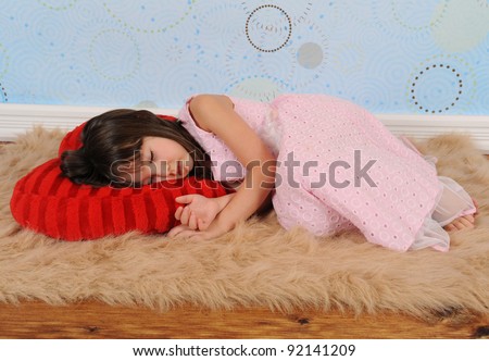 sweet little girl asleep on heart shaped valentine's pillow