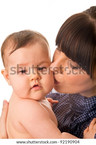 Portrait of mother kissing her baby isolated on white