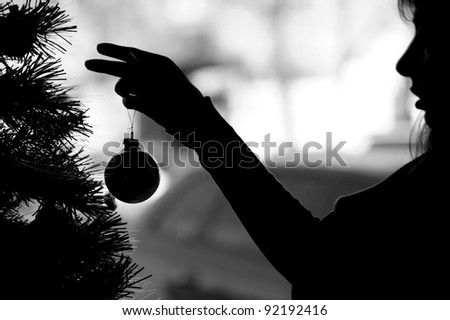 Woman silhouette dresses up Christmas tree (black white)