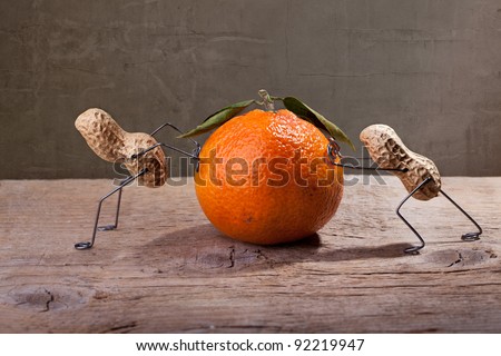 Miniature with Peanut People working against each other, failing to move the orange