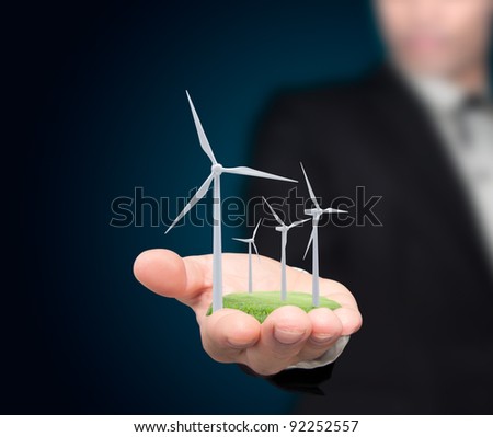 Wind turbines on the hands businessman. Royalty-Free Stock Photo #92252557
