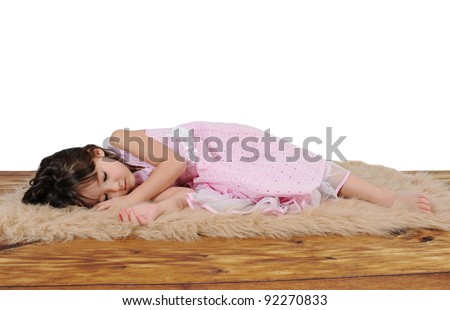 adorable little girl in dress asleep on furry brown rug. over white