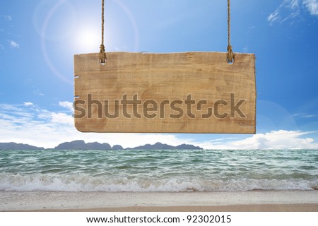 wood sign hanging on beach Royalty-Free Stock Photo #92302015