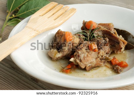 Rabbit stew with spices on wooden table