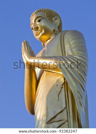 Golden buddha Statue on blue sky.