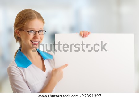 beautiful young female doctor holding a blank billboard