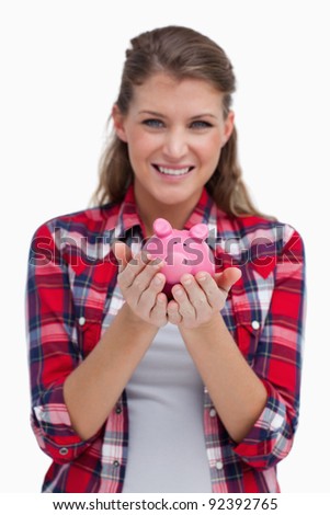 Portrait of a woman holding a piggy bank against a white background