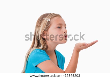 Girl blowing a kiss against a white background