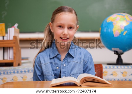 Schoolgirl reading a book in a classroom