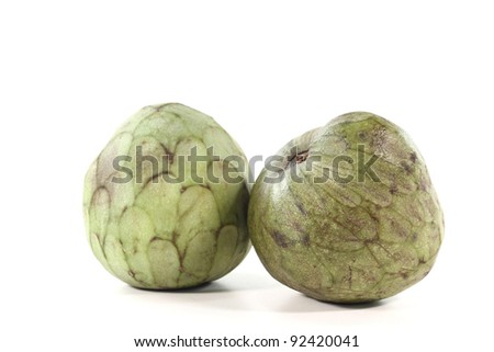 two fresh, whole, green and brown Cherimoya