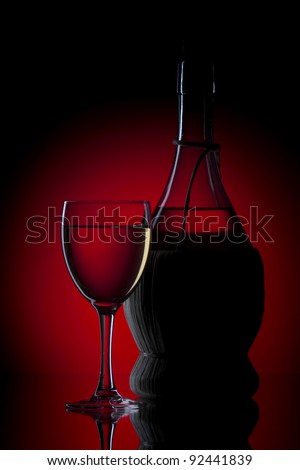 White wine wine glass. A bottle on a dark red background