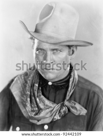 Cowboy with a hat looking sternly at the camera