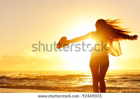carefree woman dancing in the sunset on the beach. vacation vitality healthy living concept Royalty-Free Stock Photo #92469031