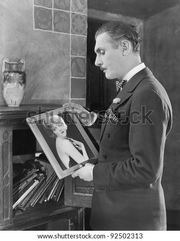 Man studying a picture of a woman