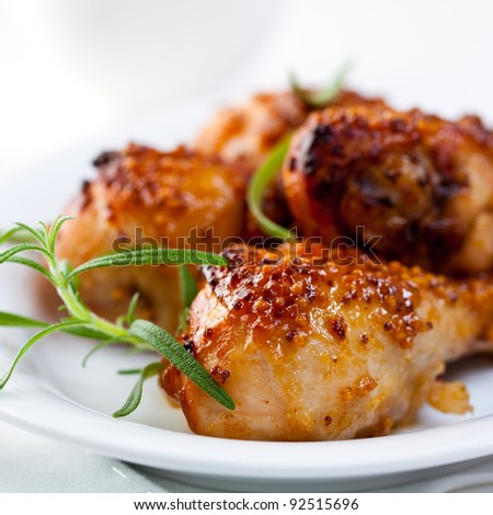 Honey and mustard glazed chicken legs. Spicy chicken legs. Baked Chicken Legs with Rosemary. Homemade food. Symbolic image. Concept for a tasty and healthy dish. Rustic wooden background. Close up Royalty-Free Stock Photo #92515696