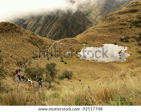 Tourists climbing the Inca trail and lake