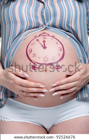 Tummy of pregnant woman with funny drawing over white background
