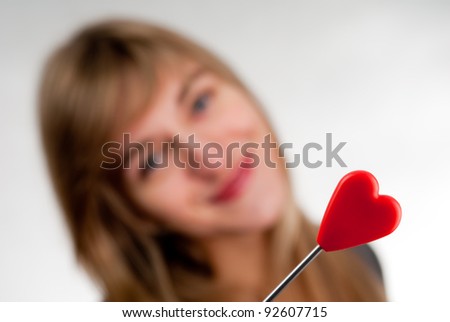 Beautiful young casual woman holding red heart, isolated on white