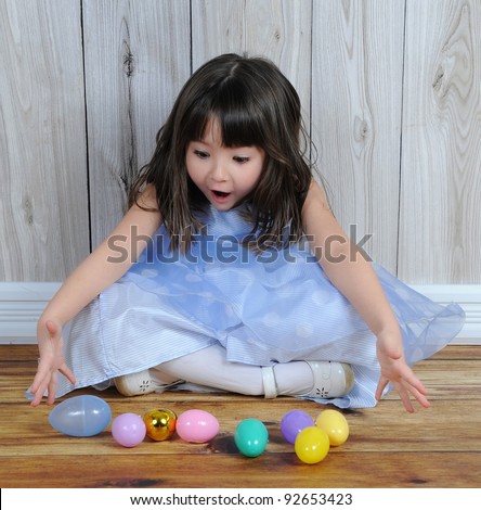 sweet little girl excited over easter eggs in front of her