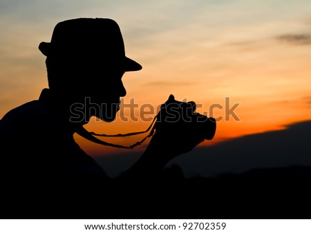  Photographer's silhouette. Photographer silhouette, staring at a camera review.