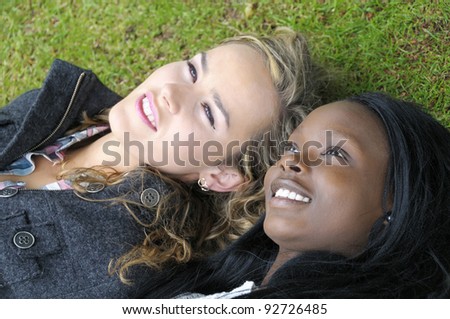 Two beautiful girls lying down. Girl on the left is slightly out of focus to enhance that dreamy look.