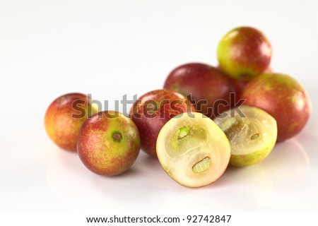 Camu camu berry fruits (lat. Myrciaria dubia) which are grown in the Amazon region (Selective Focus, Focus on the half camu camu in the front and the the complete berry to the left of it) Royalty-Free Stock Photo #92742847
