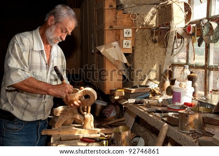 Wood worker carving wood in a derelict shed Royalty-Free Stock Photo #92746861