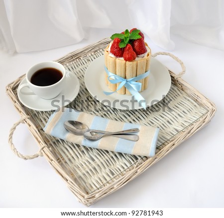 Dessert souffle with biscuit and fresh strawberries on a tray with a cup of coffee