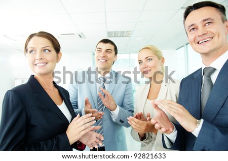 Photo of business partners applauding while looking at spokesman