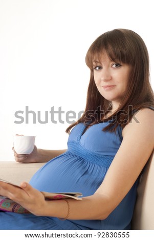 pregnant girl in a dress rests on sofa