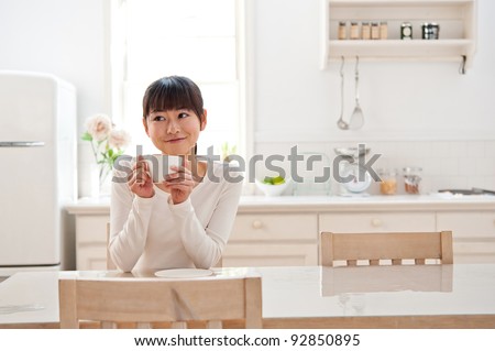 attractive asian woman relaxing in the kitchen Royalty-Free Stock Photo #92850895