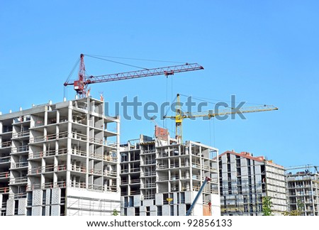 Crane and building construction site against blue sky Royalty-Free Stock Photo #92856133
