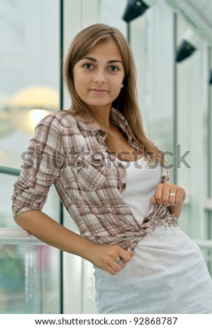 girl in a plaid shirt near a large window