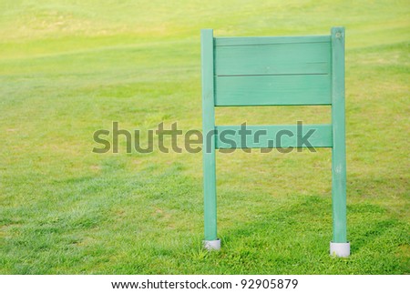 Wooden sign copy space board on green field